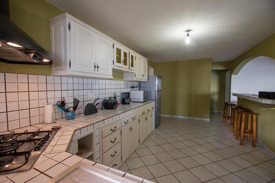 a kitchen with white cabinets and a counter top at Leu Pied Dans L&#39;Eau in Saint-Leu