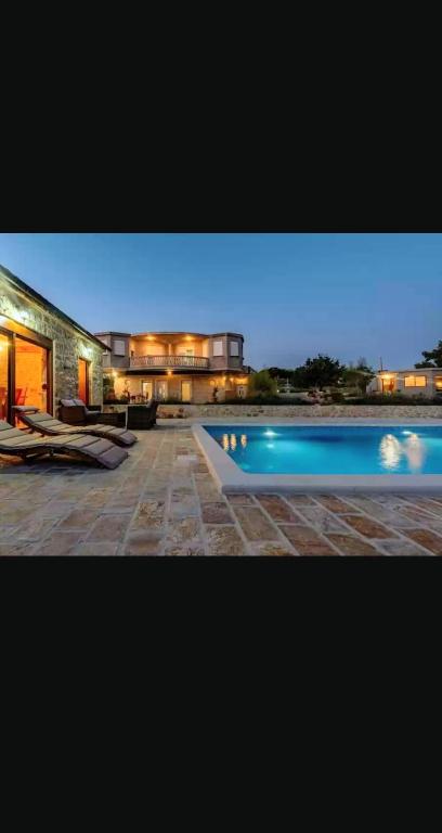 a house with a swimming pool in front of it at VILLA DOCI in Zadar