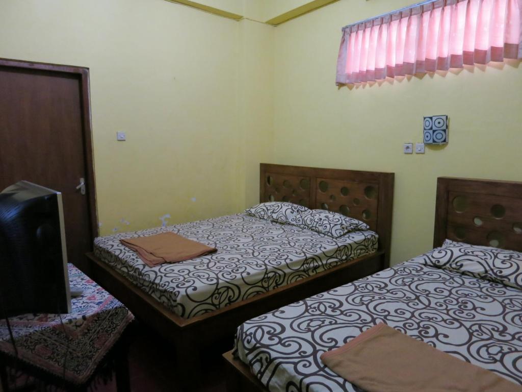 Postel nebo postele na pokoji v ubytování Sartika Hotel Prawirotaman