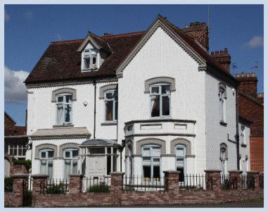 a white house with a fence in front of it at The Lodge in Kings Lynn