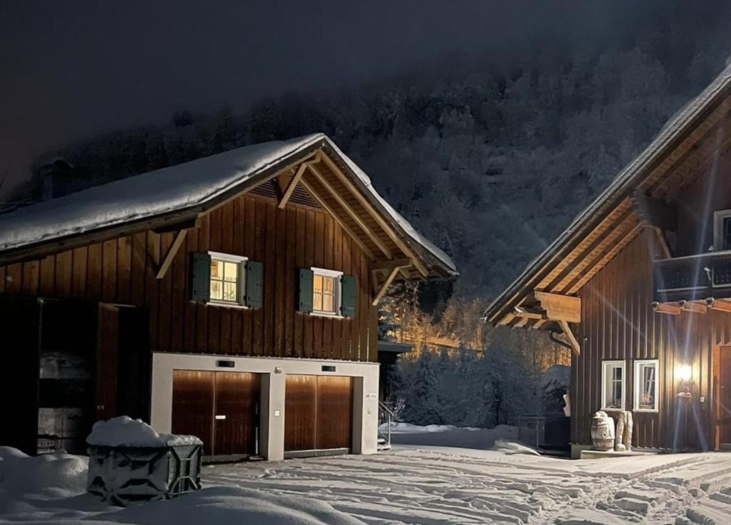 a wooden house with a garage in the snow at Chalet Milanovic in Dalaas