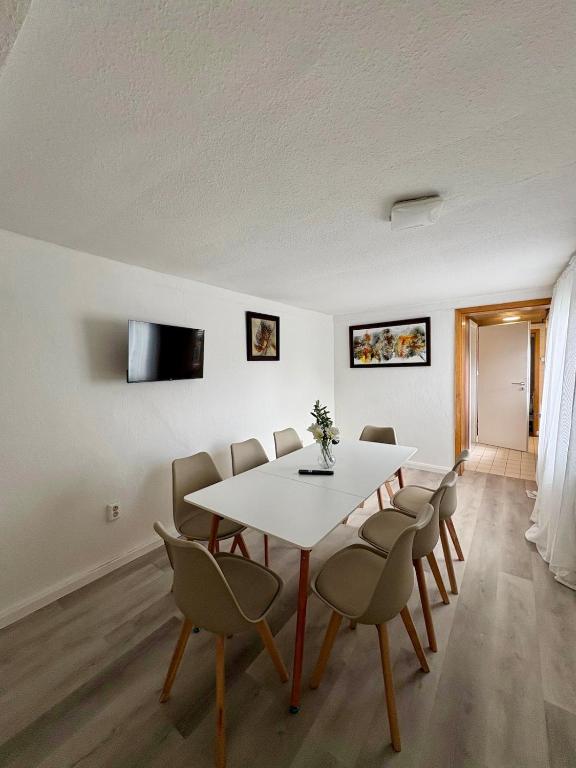 a dining room with a white table and chairs at geräumiges Monteurapartment 2 in Bensheim mit Parkplatz in Bensheim
