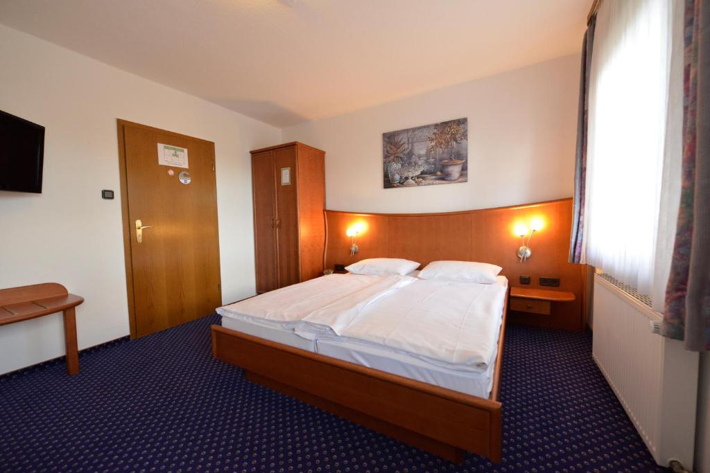 um quarto com uma cama grande e uma janela em Trollinger Hof em Bad Oeynhausen