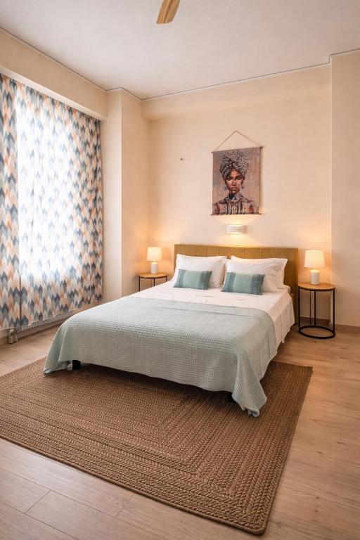 a bedroom with a large bed and a large window at Aurora Apartments in Mytilene