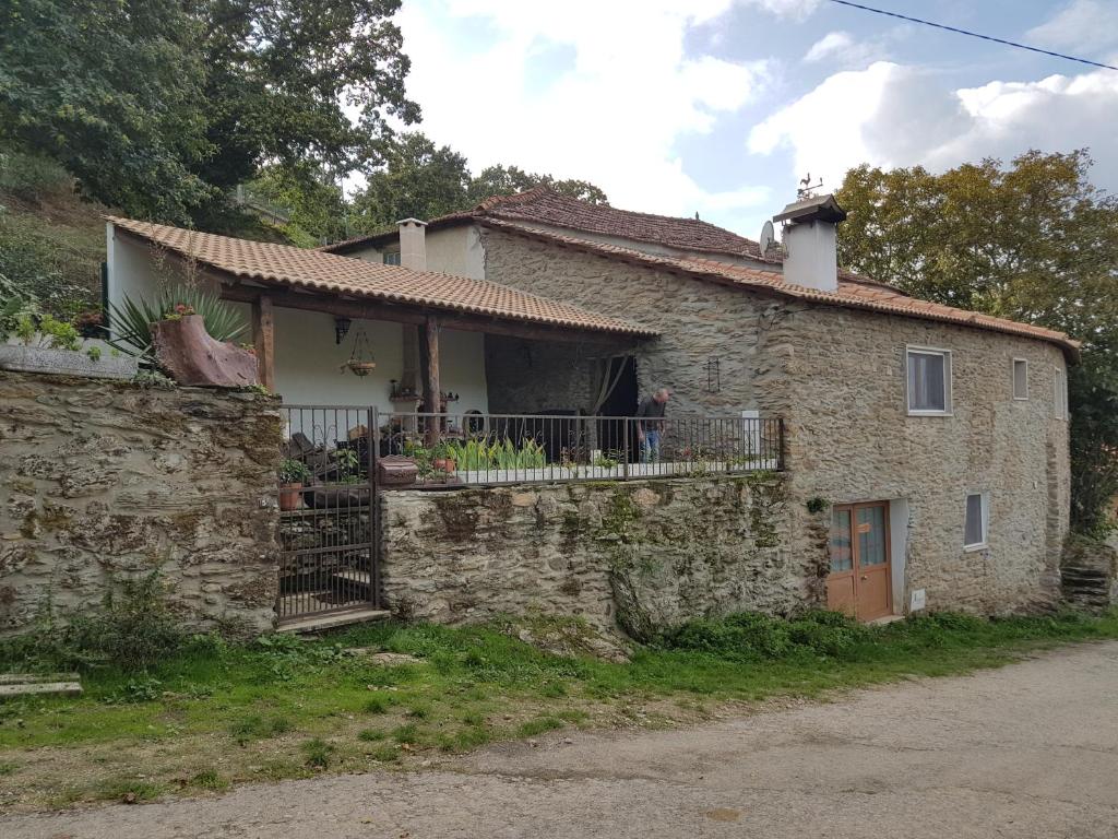 una casa de piedra con un balcón en un lateral. en Casa da Zeza, en Negreda