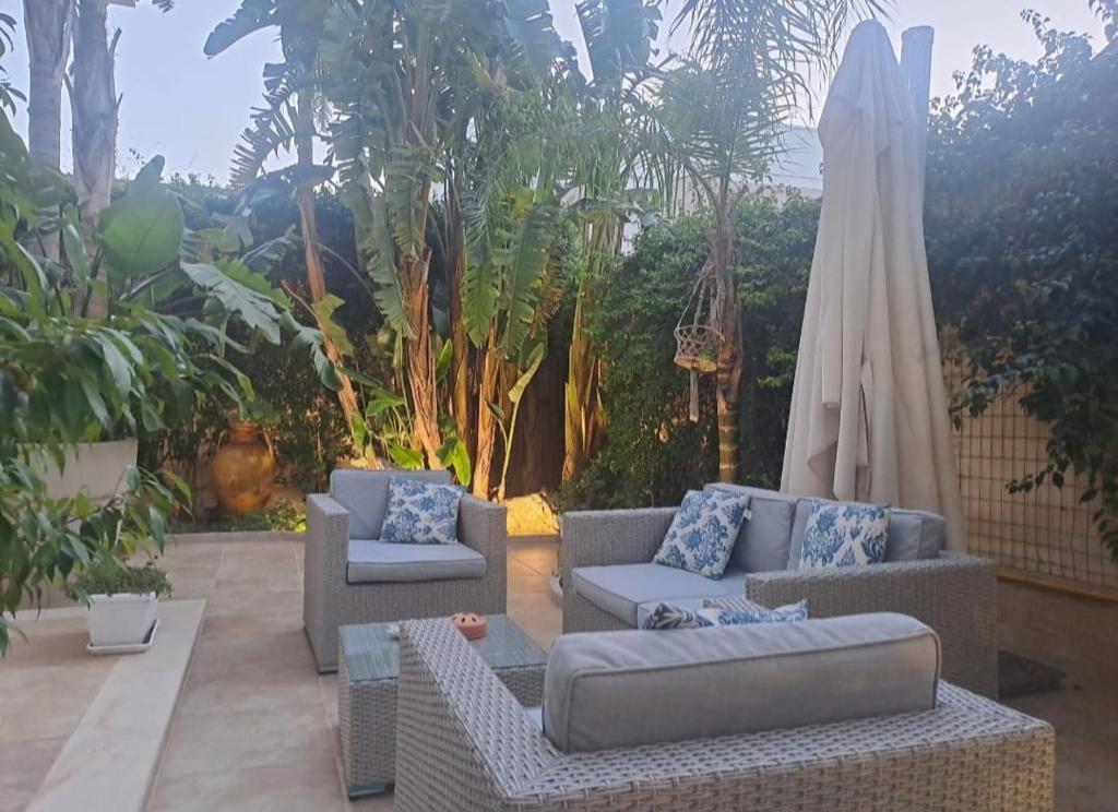a patio with two couches and an umbrella and an umbrella at Falli Exclusive Rooms and Breakfast -Boutique B&B- in Porto Cesareo