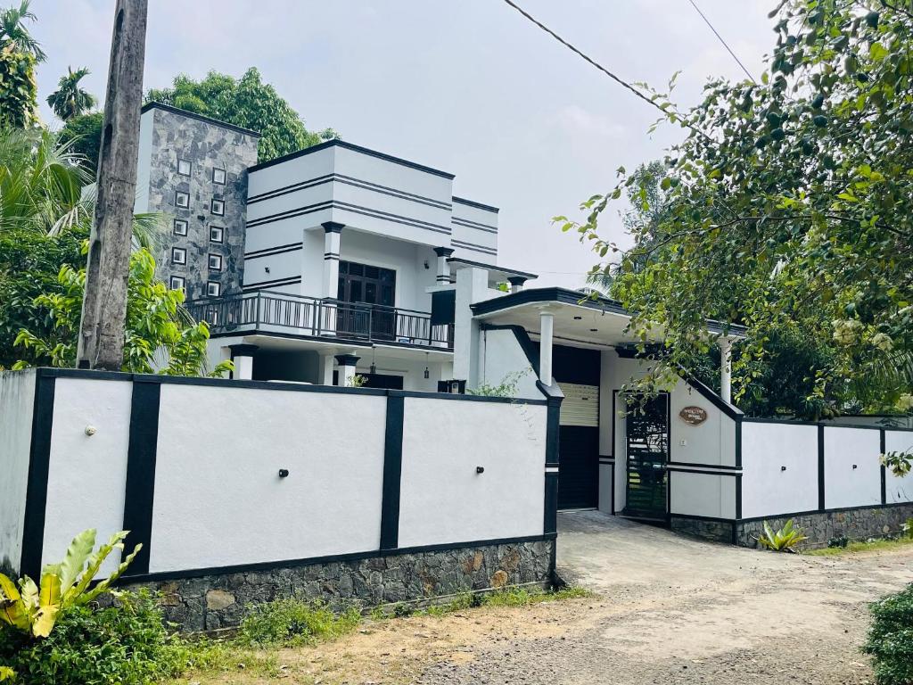 a white house with a black and white gate at Dream villa in Imaduwa