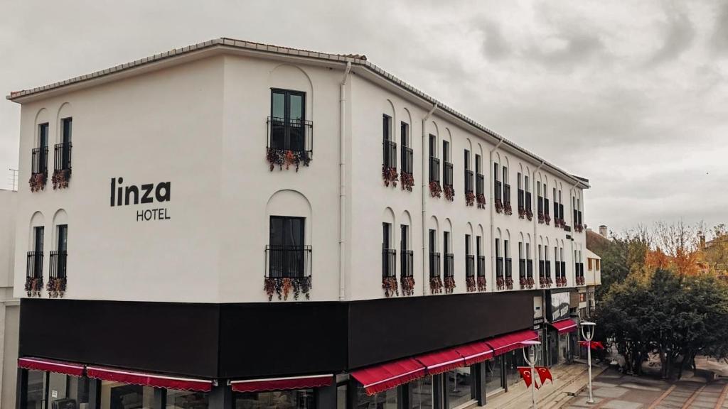 a white building with windows and balconies on a street at Linza Suite in Babaeski