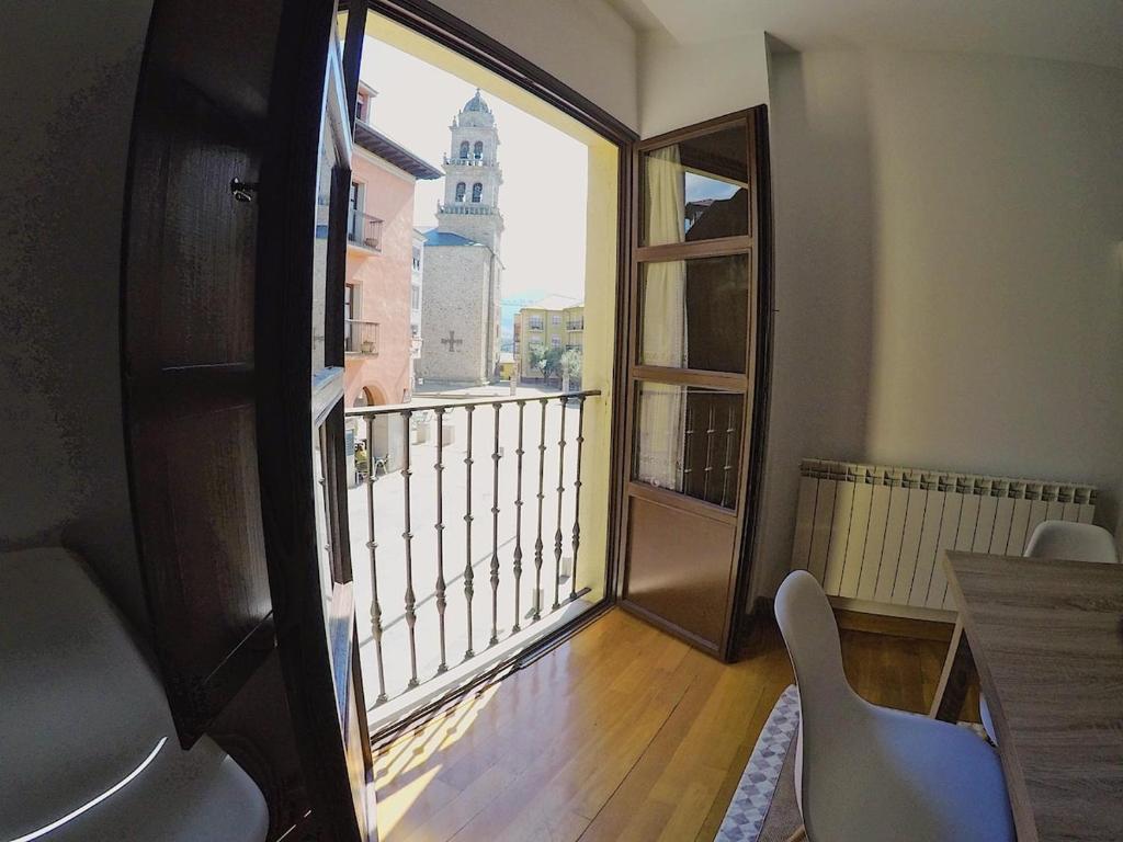 a room with a balcony with a view of a building at El Balcón de la Encina in Ponferrada