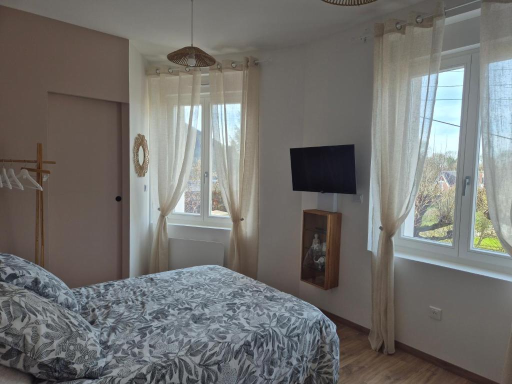 a bedroom with a bed and a tv and windows at St FURSY 2 in Péronne