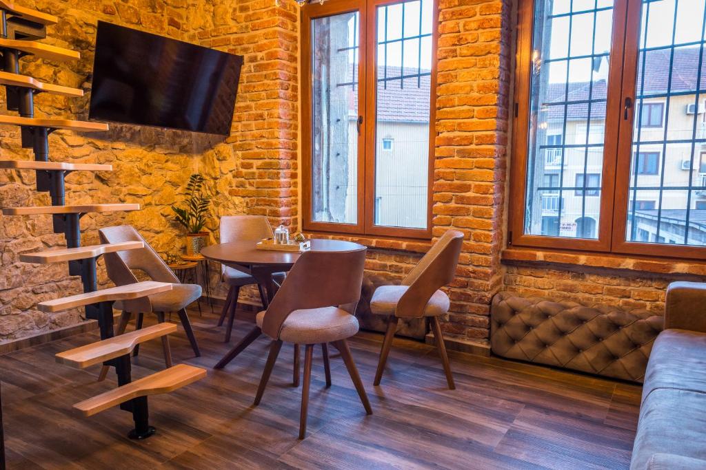 a dining room with a table and chairs and a couch at Sky Apartman 2 in Kučevo
