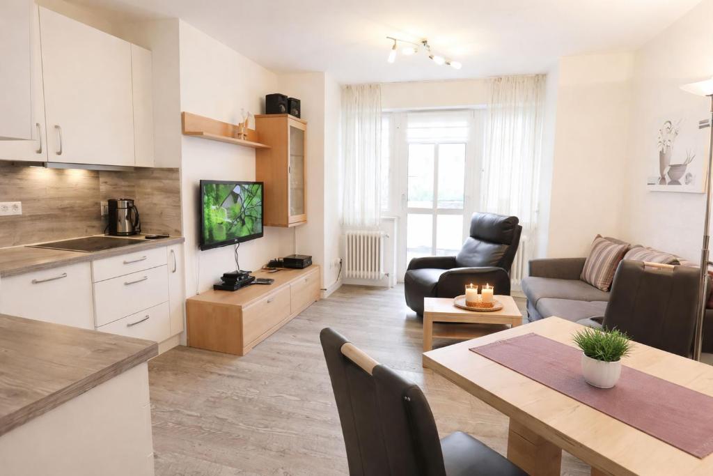 a kitchen and living room with a table and a couch at Boje 5 in Schillig