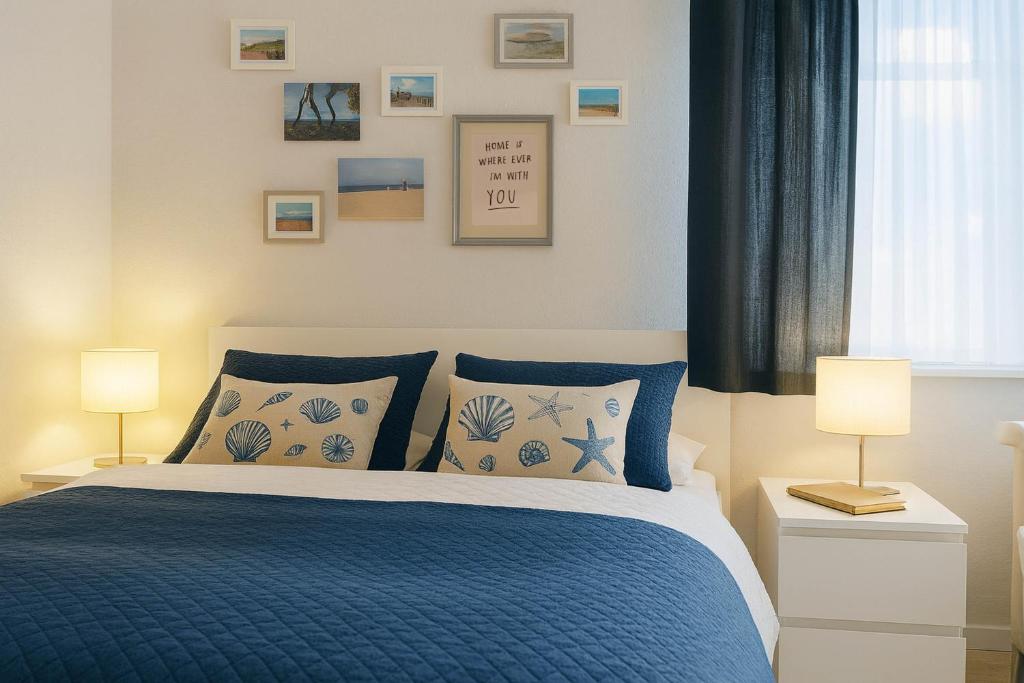 a bedroom with a blue bed and two lamps at Boje 7 in Schillig
