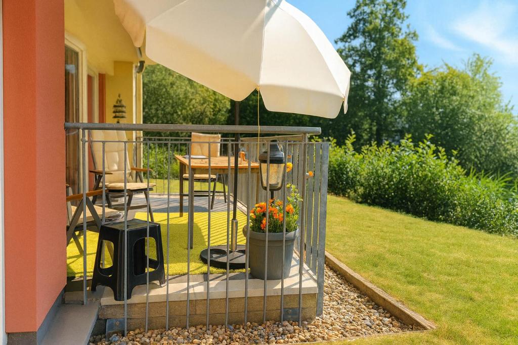 eine Terrasse mit Sonnenschirm, Tisch und Stühlen in der Unterkunft Granata in Schillig