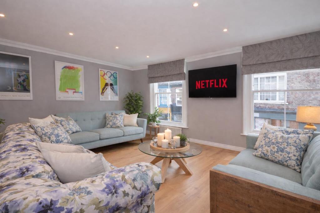 a living room with two couches and a table at Fossgate Luxury Duplex City Centre Apartment with Free Parking in York