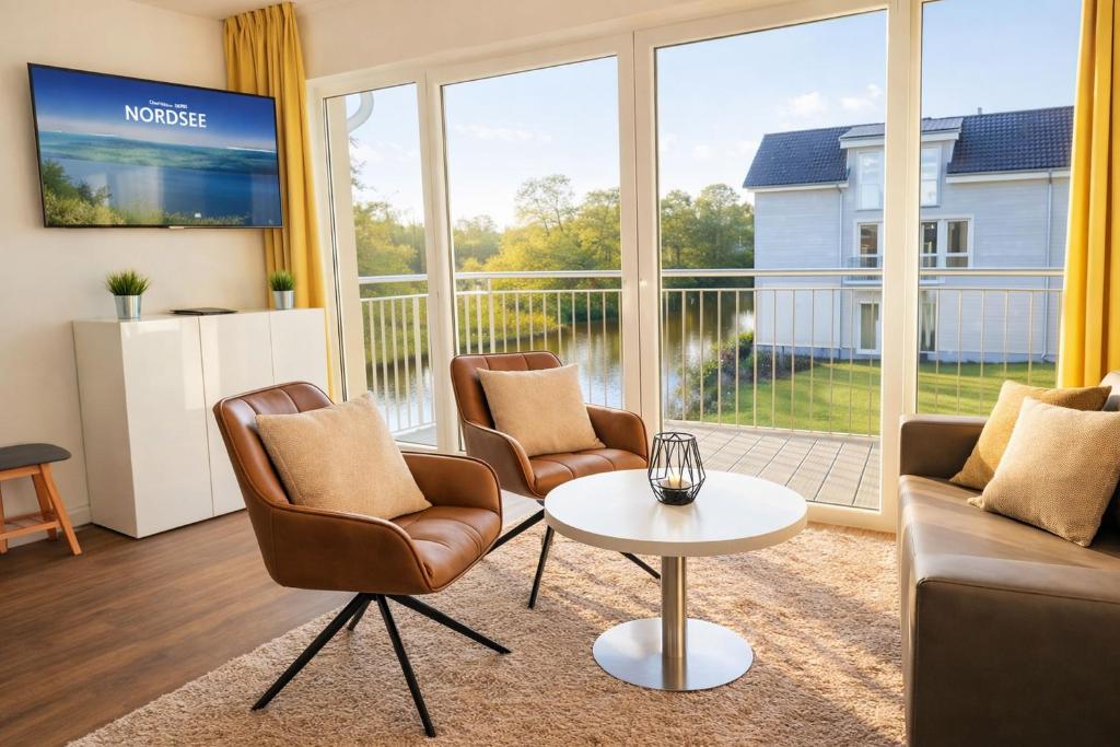 a living room with a couch and chairs and a table at Strandnah in Schillig