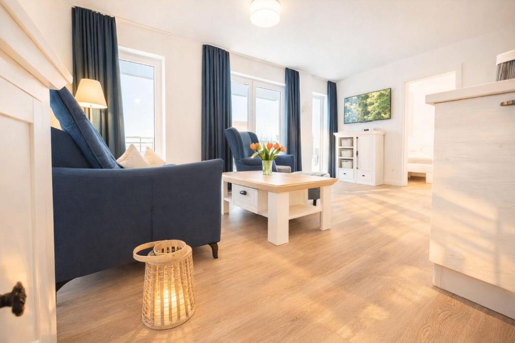 a living room with a blue couch and a table at Leuchtfeuer in Schillig