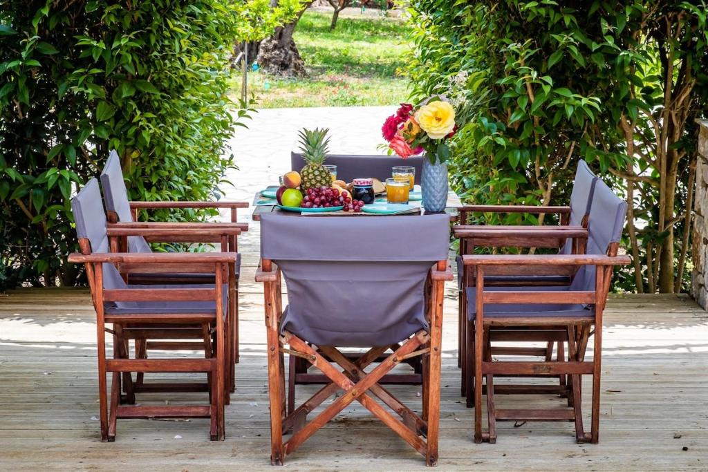 a table with two chairs and a table with fruit on it at Unique Filoxenia! in Skopelos Town