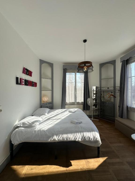 a bedroom with a bed in a room with windows at Studio avec vue sur le Château in Azay-le-Rideau