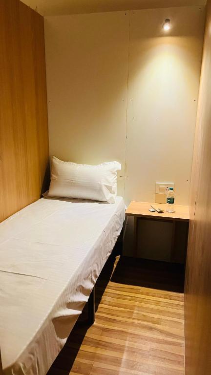 a small room with a bed and a desk at FarGo Hotels By Lowfare Hotels in Bangalore