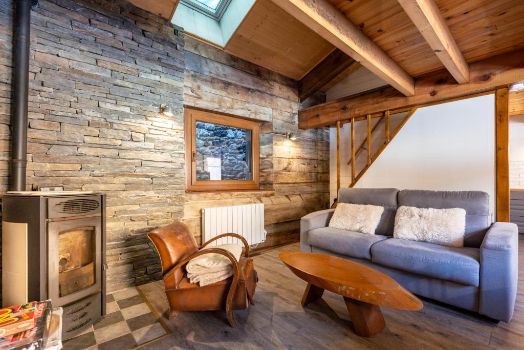 a living room with a couch and a fireplace at L’Écrin des Neiges - Proche Station de Ski in Formiguères