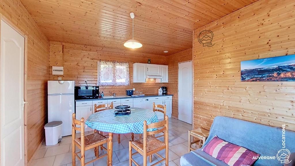 a kitchen with a table and a small kitchen with a refrigerator at Chalet de la Gougère 3 in Chambon-sur-Lac