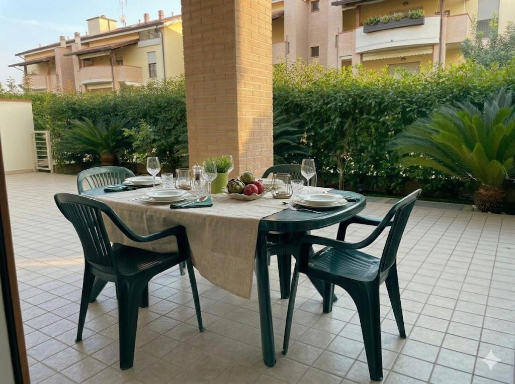 a table with chairs and wine glasses on a patio at PIOPPETO OVEST - Premium Villas in Giulianova