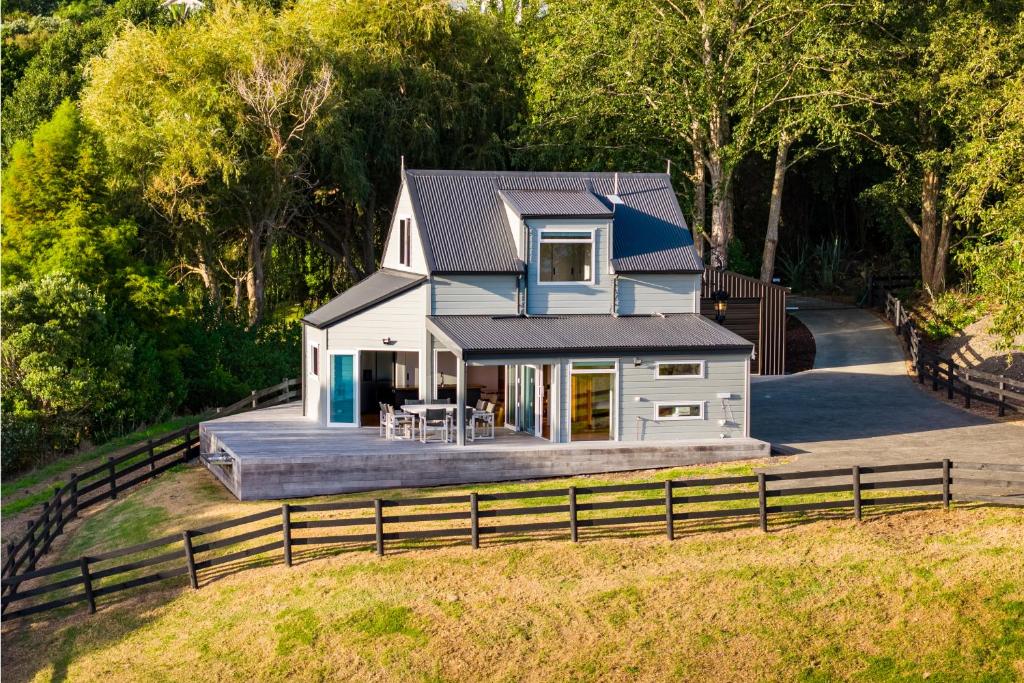 a house on a hill with a fence at Reotahi Bolthole in Whangarei Heads