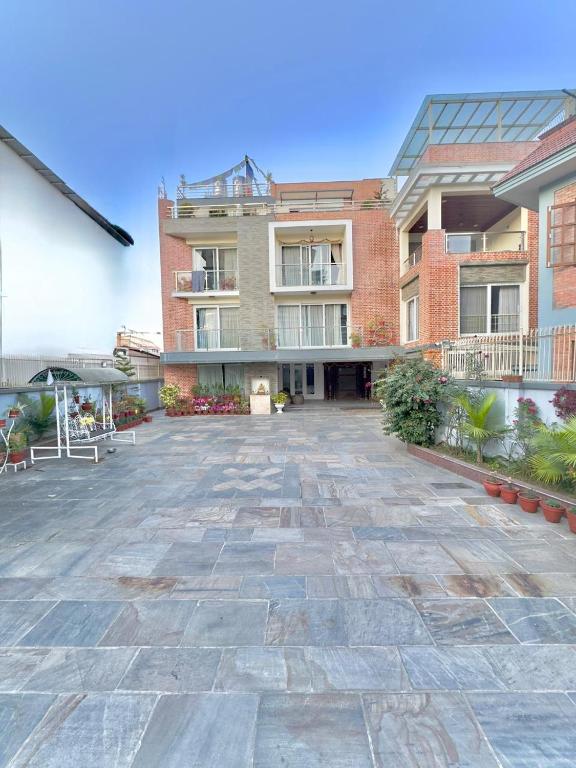a large brick building with a stone courtyard at Triluna Apartments in Pātan