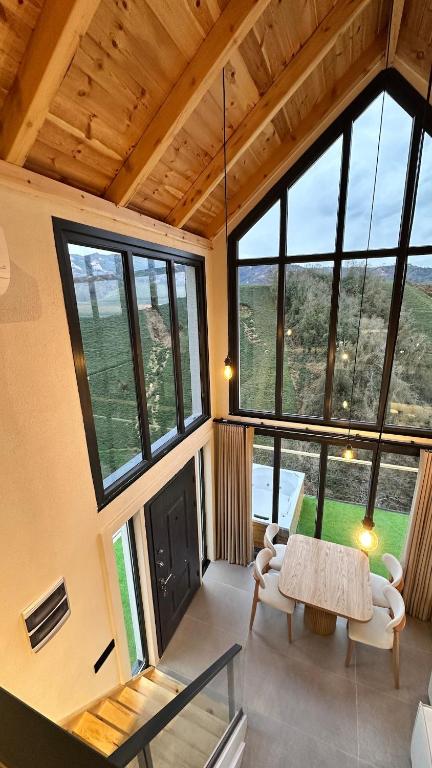 a room with a table and chairs and windows at Çavdi Villa in Ardeşen