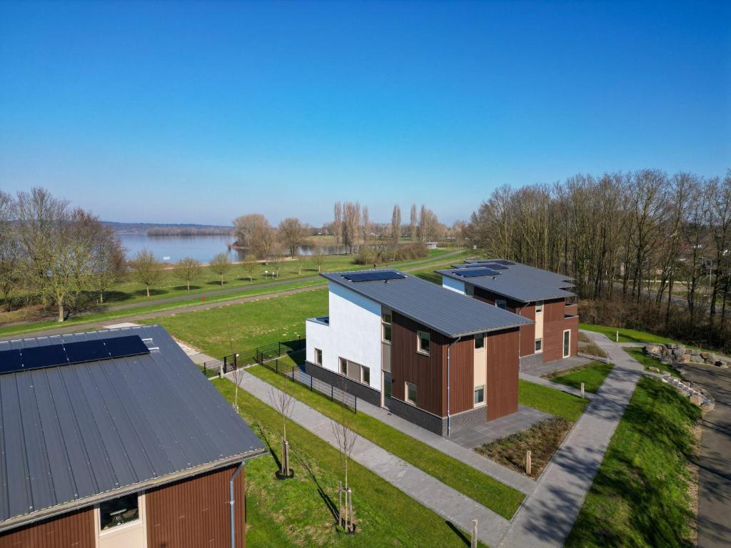 an aerial view of a row of houses with a lake at Kooparc in Giesbeek