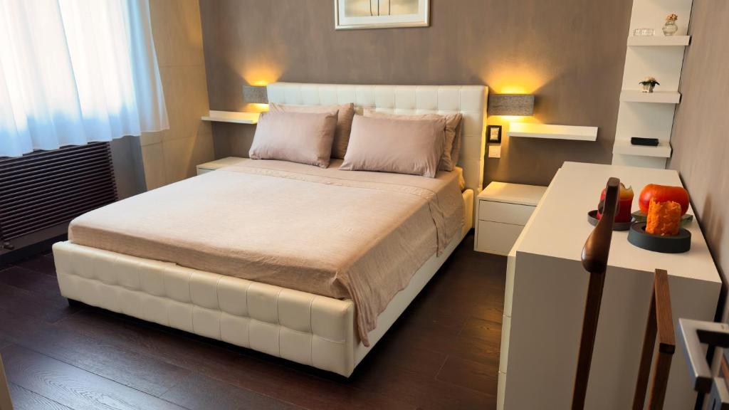 a bedroom with a white bed and a table at Giulia By The Sea in Follonica