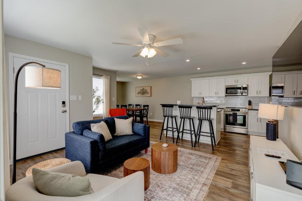 a living room with a blue couch and a kitchen at Mimosa Getaway - Thomasville Fun! in Thomasville