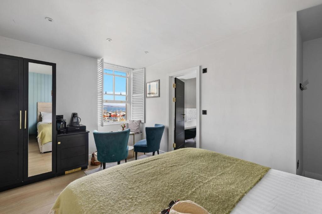 a bedroom with a bed and a desk and chairs at Leader Suite - Sea View - Free Wi-Fi in Brixham