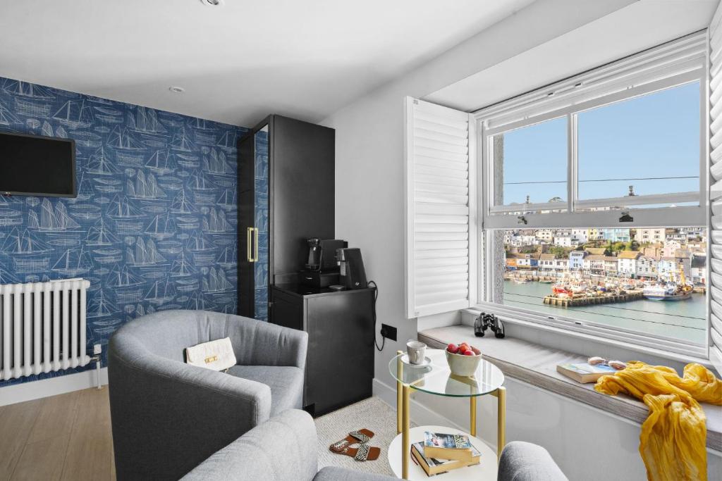 a living room with a couch and a window at Vigilance Suite - Free Wi-Fi - Sea View in Brixham