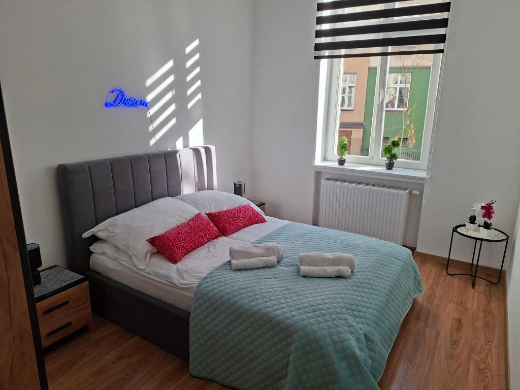 a bedroom with a bed with two towels on it at Apartament City Dream in Legnica