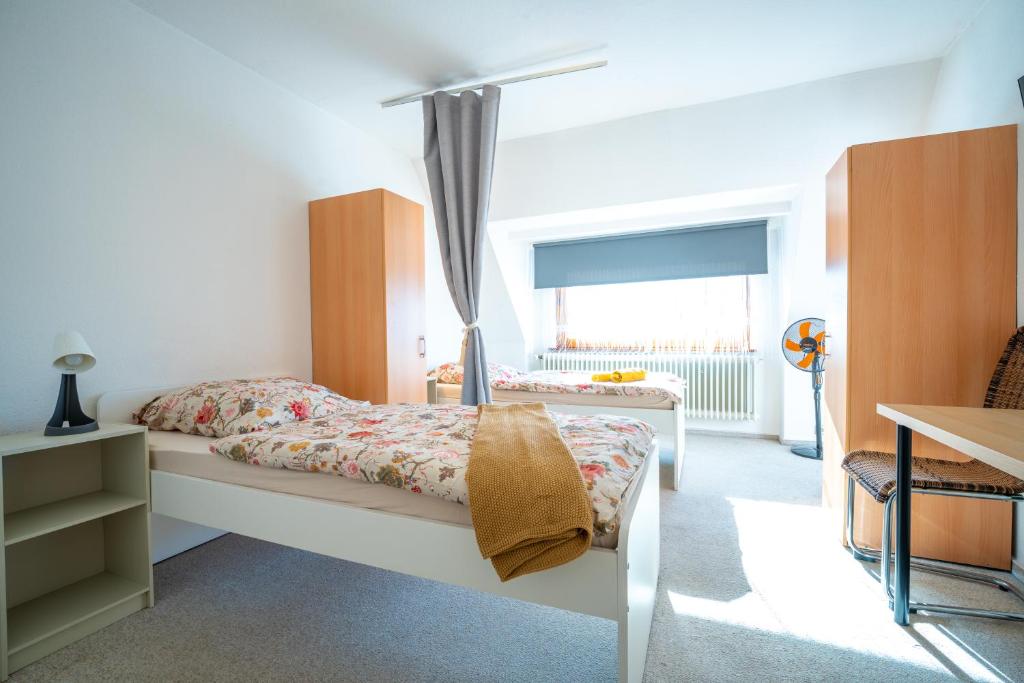 a bedroom with a bed and a desk and a window at Space Comfort Bremen Apartment bis zu 6 Personen in Bremen