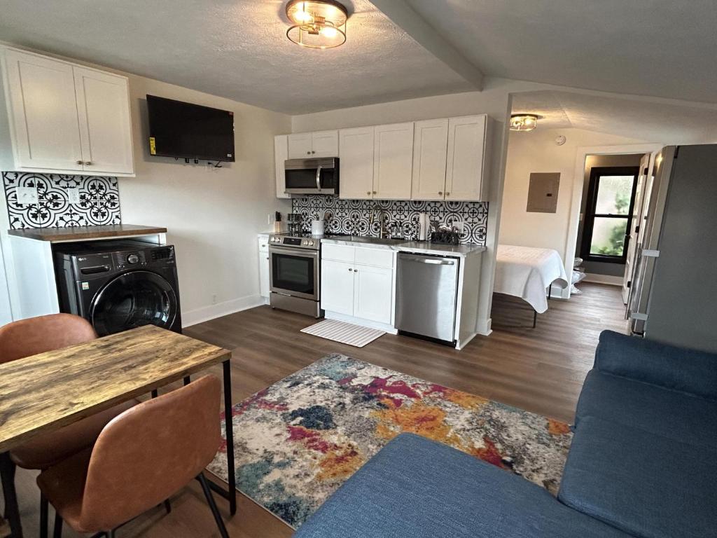 a kitchen with white cabinets and a living room at Victorian Queen Getaway Unit C Washerdryer in Muskegon