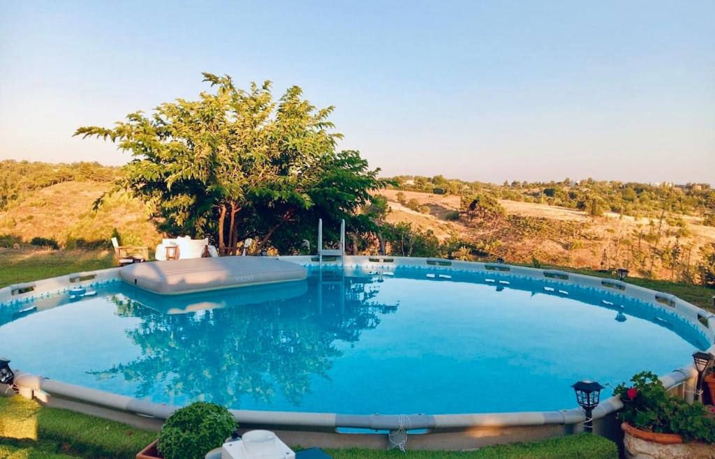 a large blue swimming pool in a yard at Mountain pool house in Varnávas