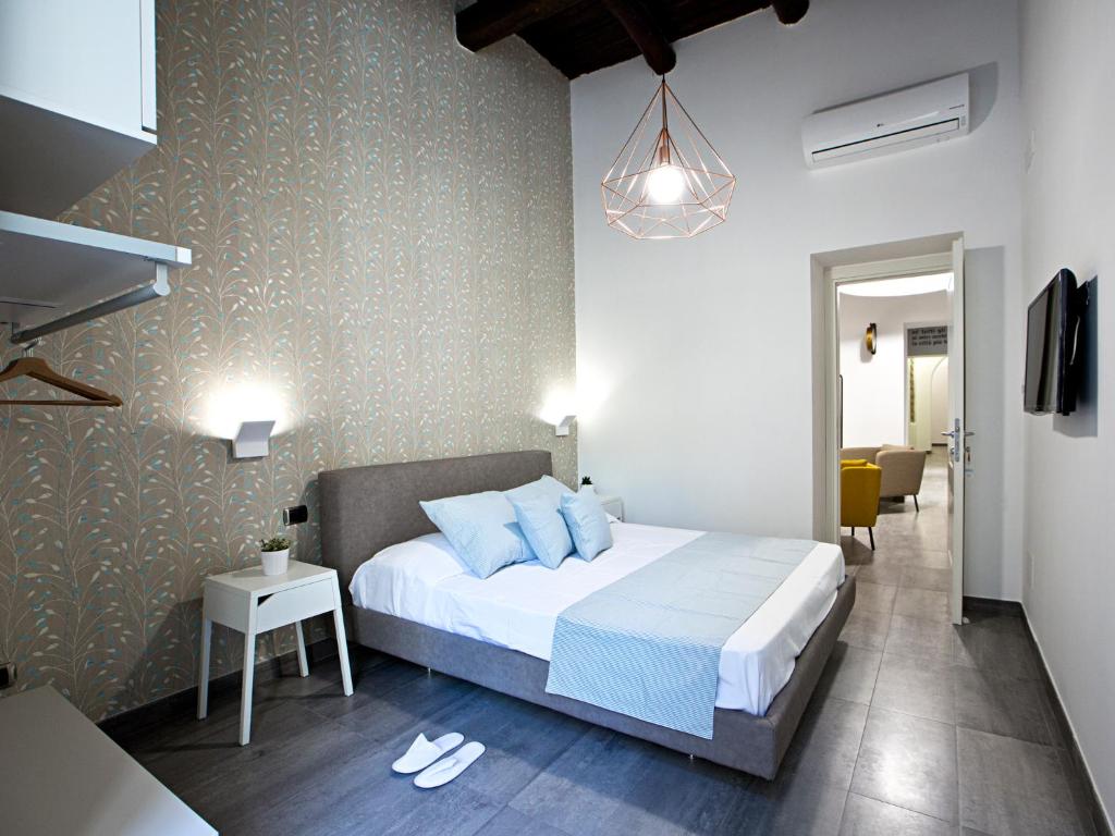 una camera da letto con un grande letto con cuscini blu di Parthenope Suite a Napoli