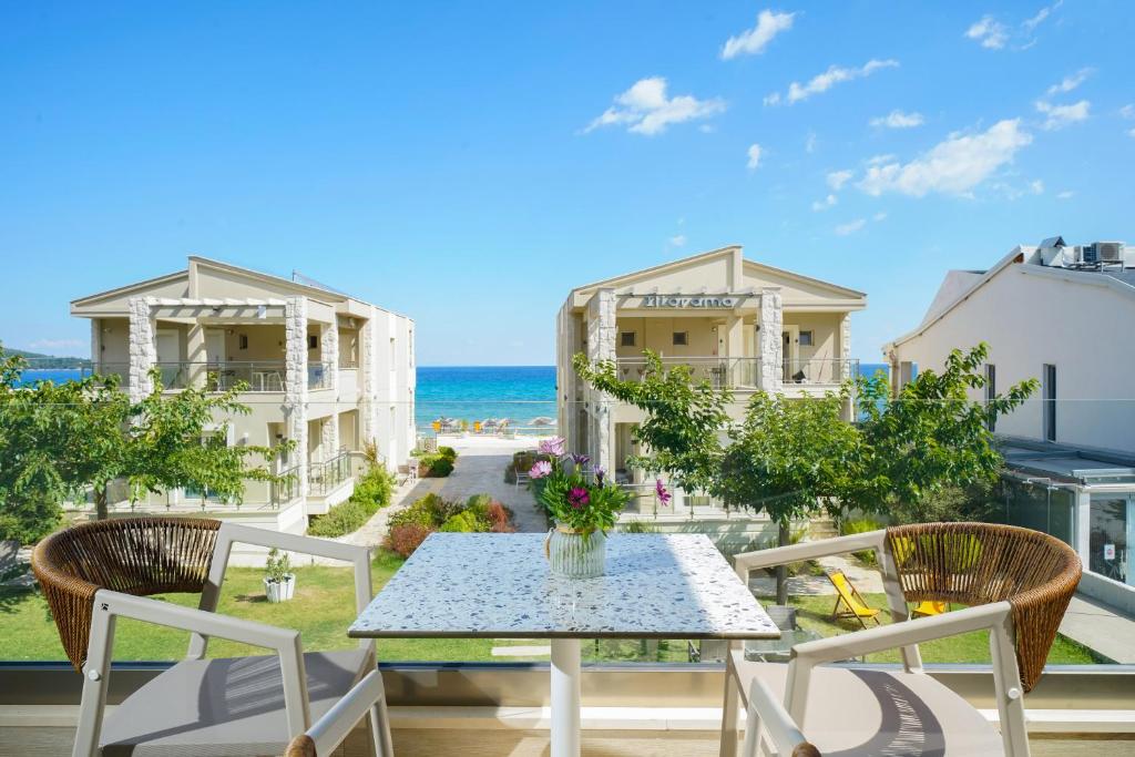 a patio with a table and chairs and the ocean at ILIORAMA LUXURY SUITES in Skala Potamias