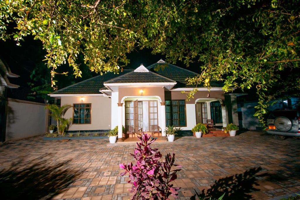a small white house with a brick driveway at Lasai casa in Arusha