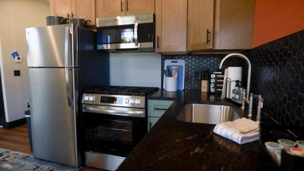 a kitchen with a stainless steel refrigerator and a sink at Modern Queen Apartment At The Victorian Unit E in Muskegon