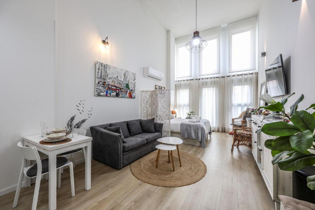 a living room with a couch and a table at Fancy Studio with Terrace & Pool - Madrid South in Villaverde