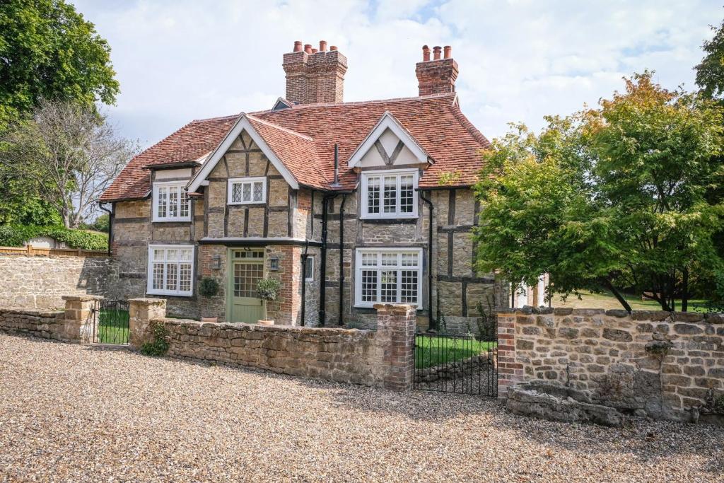 an old stone house with a brick wall at Challens Yarde in Midhurst