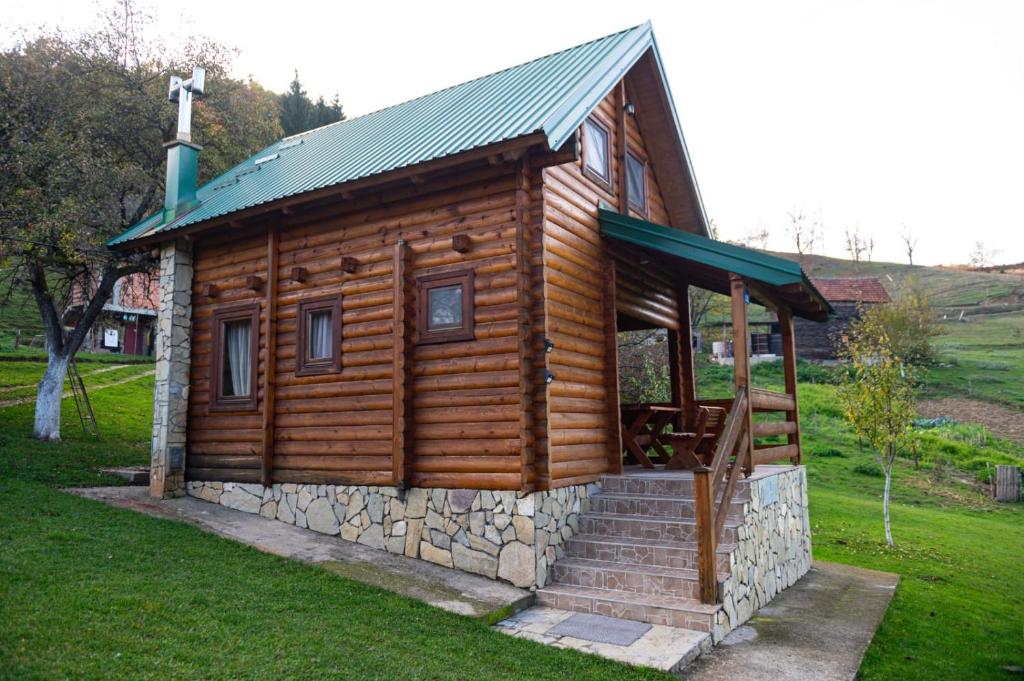 a wooden cabin with stairs in a field at Koliba Bajka in Bijelo Polje