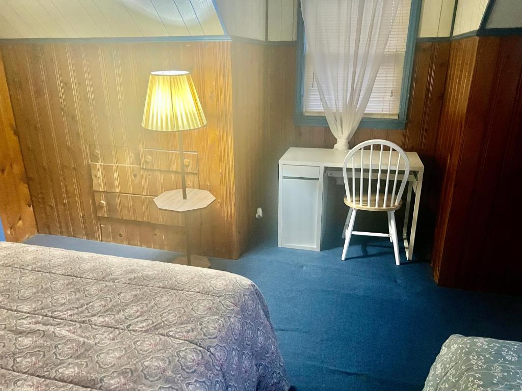 a bedroom with a bed and a desk and a chair at Isa-e Home Stay in Hempstead