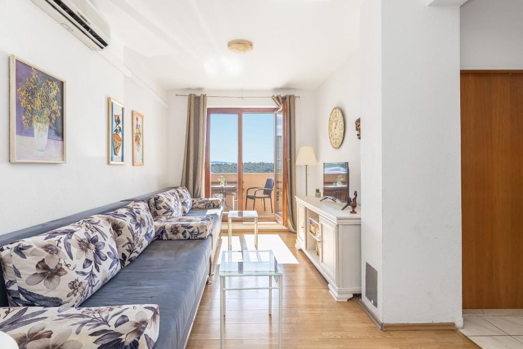 a living room with a couch and a kitchen at Sweet Escape in Makarska