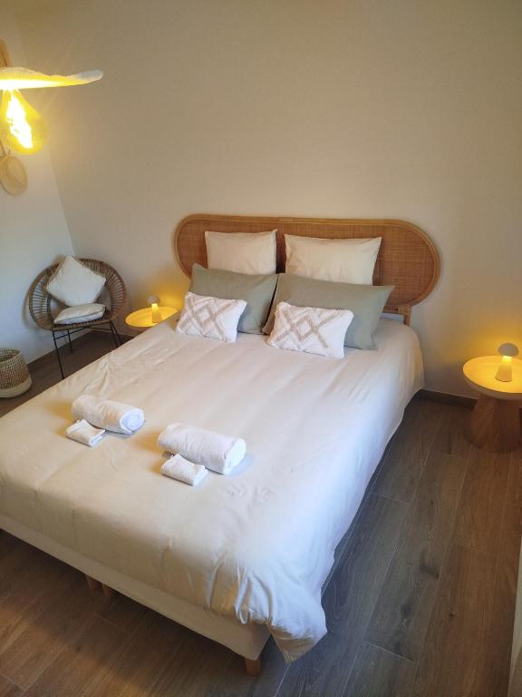 Chambre d'hôtes Tout Simplement في Beaurepaire: سرير أبيض كبير عليه منشفتان