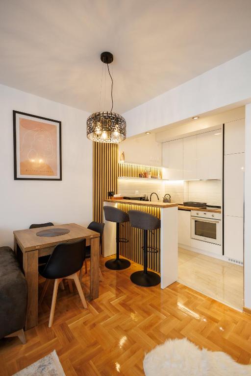 a kitchen and living room with a table and chairs at MaxInn 14 in Pirot